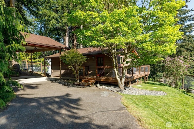 view of front of home featuring a wooden deck, driveway, and a front lawn