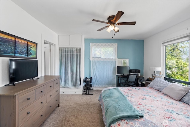 bedroom with a ceiling fan, multiple windows, and carpet floors