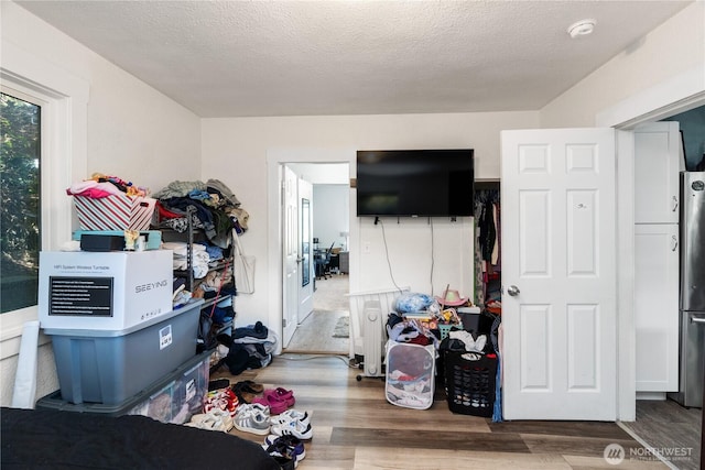 bedroom featuring freestanding refrigerator and wood finished floors