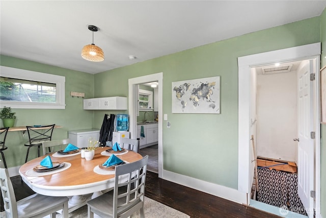 dining area with dark wood-type flooring and baseboards