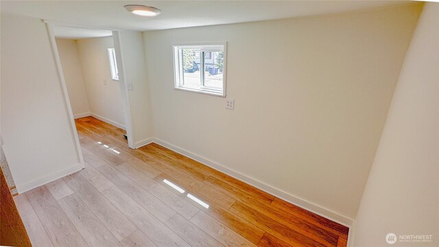 spare room featuring baseboards and light wood-type flooring