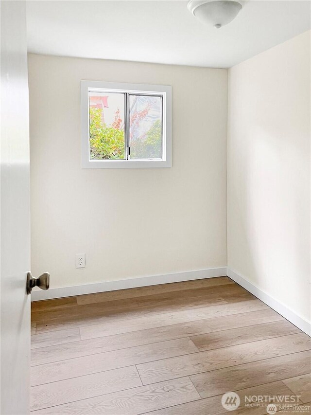 empty room with baseboards and hardwood / wood-style floors