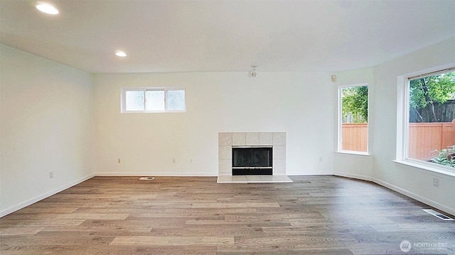 unfurnished living room featuring a fireplace, wood finished floors, visible vents, and recessed lighting