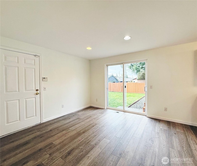 unfurnished room with dark wood-style flooring, recessed lighting, and baseboards