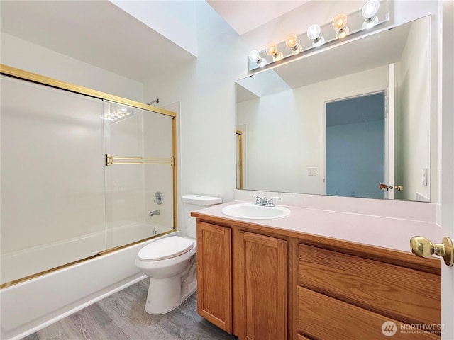 full bath with toilet, vanity, combined bath / shower with glass door, and wood finished floors