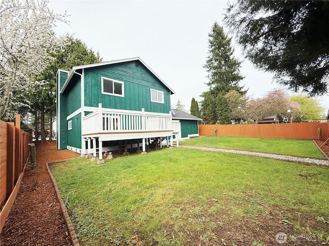 back of property featuring a fenced backyard, a wooden deck, and a yard