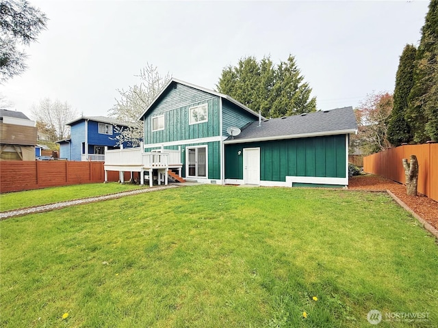 back of property with a lawn, a fenced backyard, and board and batten siding