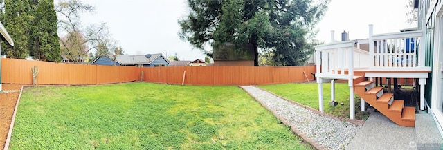 view of yard with a fenced backyard and a wooden deck