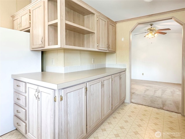 kitchen with a ceiling fan, light countertops, light colored carpet, and light brown cabinetry