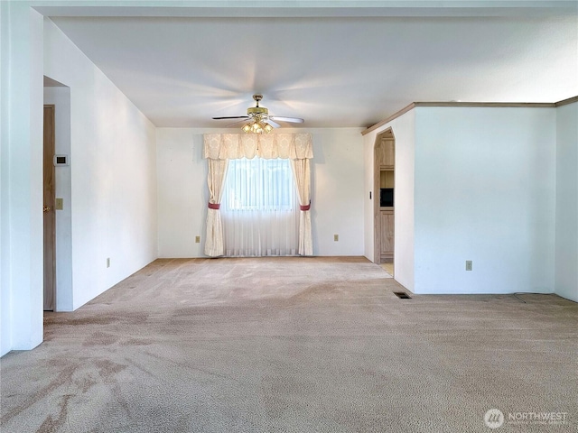 carpeted spare room with a ceiling fan