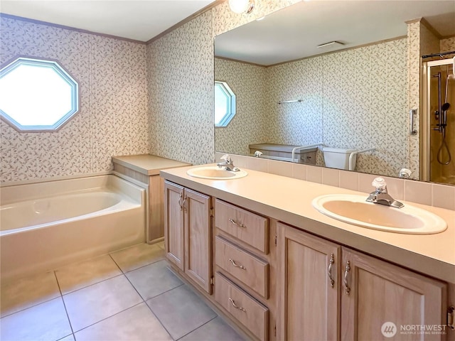 bathroom with tile patterned floors, crown molding, a bath, double vanity, and wallpapered walls