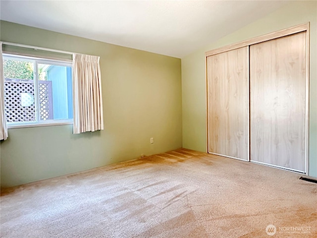 unfurnished bedroom featuring carpet flooring and a closet