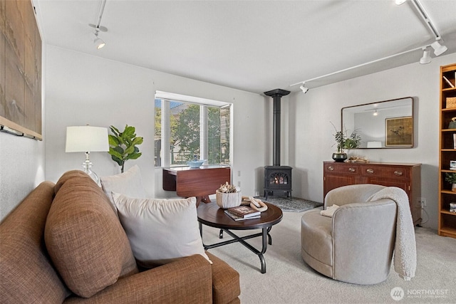 carpeted living room with track lighting and a wood stove