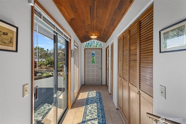 doorway to outside with wooden ceiling, light tile patterned flooring, and lofted ceiling