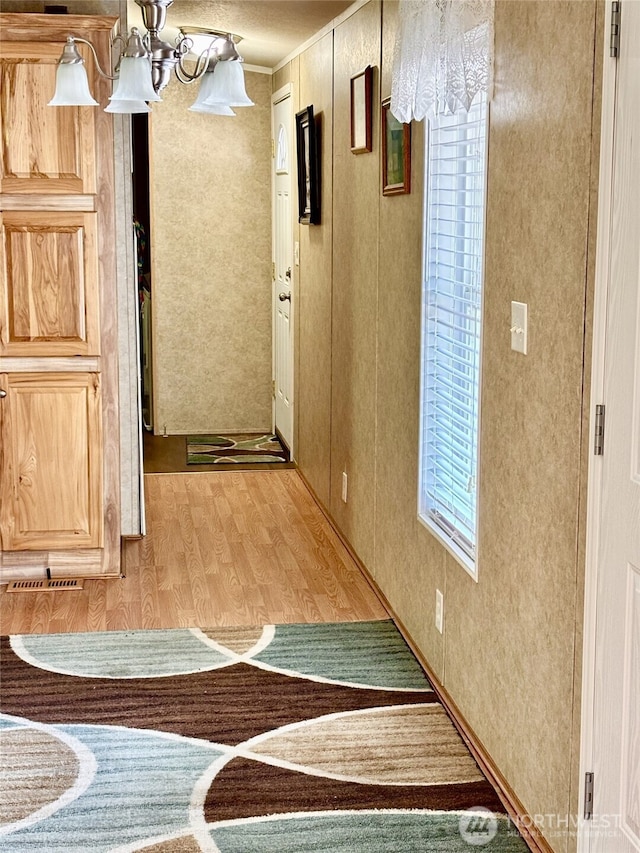 hallway featuring ornamental molding and light wood finished floors
