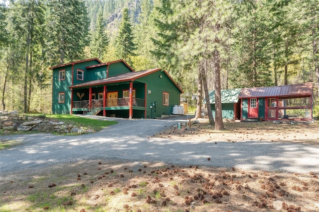 rustic home with a view of trees and covered porch