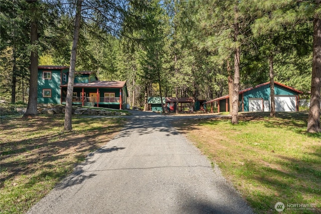 view of street featuring driveway and a wooded view