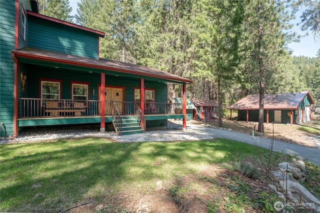rustic home featuring a porch, a wooded view, and a front yard