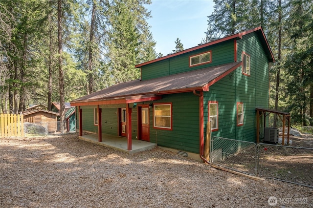 exterior space with a patio, central AC unit, roof with shingles, and fence