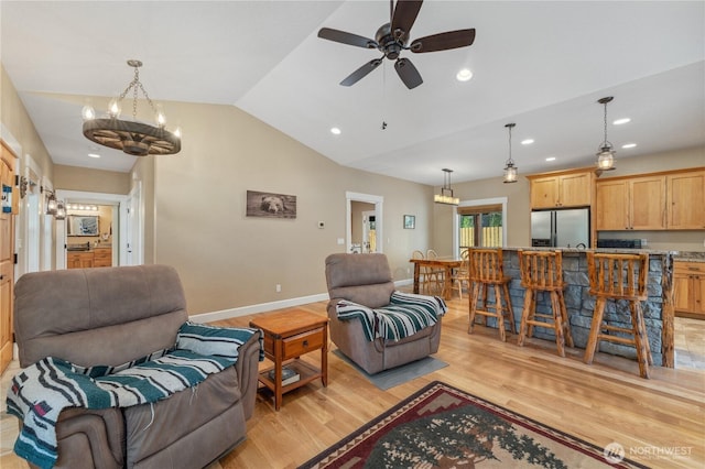living room with baseboards, ceiling fan with notable chandelier, light wood finished floors, lofted ceiling, and recessed lighting