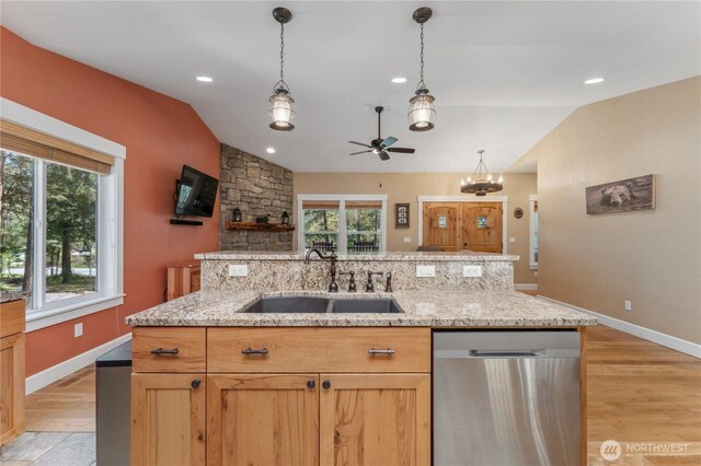 kitchen with a healthy amount of sunlight, a sink, ceiling fan with notable chandelier, dishwasher, and vaulted ceiling