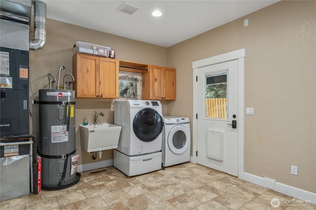 laundry area with secured water heater, baseboards, cabinet space, and washer and dryer