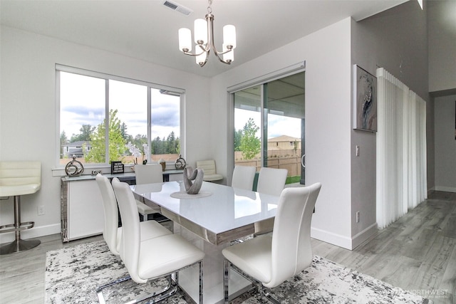 6318 230th Avenue Ct E, Buckley, WA 98321 - dining area with light wood-style floors, visible vents, baseboards, and an inviting chandelier