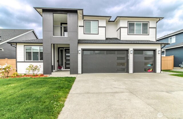 6318 230th Avenue Ct E, Buckley, WA 98321 - view of front of home with a front lawn, driveway, a shingled roof, an attached garage, and fence