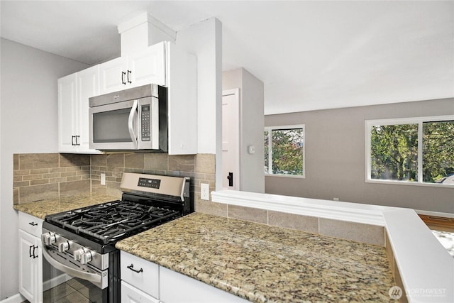 240 Willow St, Bremerton, WA 98310 - kitchen with light stone counters, white cabinetry, appliances with stainless steel finishes, and tasteful backsplash