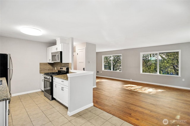 240 Willow St, Bremerton, WA 98310 - kitchen with stainless steel appliances, baseboards, white cabinetry, and tasteful backsplash