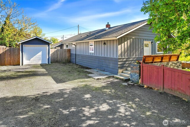 240 Willow St, Bremerton, WA 98310 - view of side of property with roof with shingles, board and batten siding, fence, a garage, and an outdoor structure