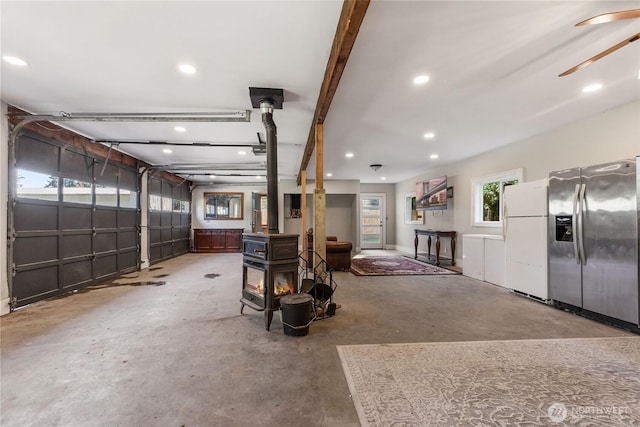 1812 N Pearl St, Centralia, WA 98531 - garage with recessed lighting, stainless steel fridge, a wood stove, and white refrigerator with ice dispenser