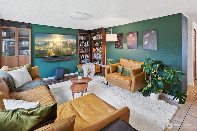 sitting room with baseboards, a textured ceiling, and tile patterned floors