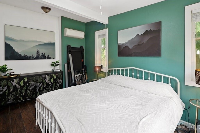 bedroom with a wall mounted AC and hardwood / wood-style floors