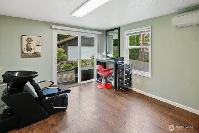 office area with an AC wall unit, plenty of natural light, and wood finished floors