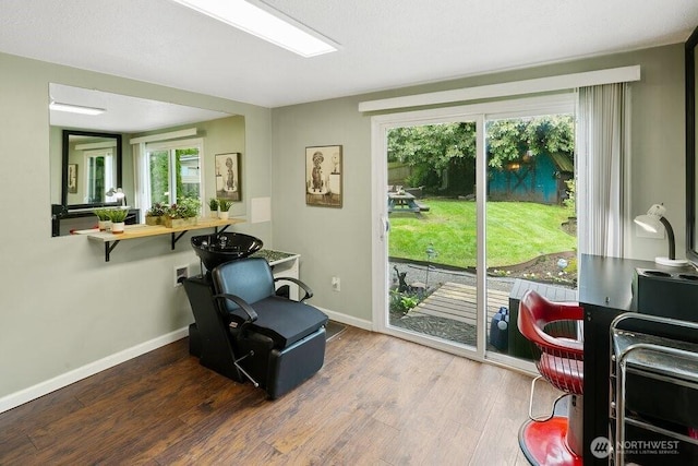 living area with a healthy amount of sunlight, baseboards, and wood finished floors