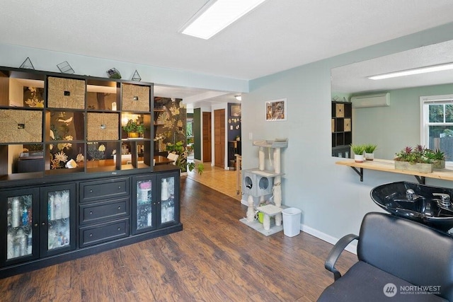 bar featuring baseboards, a wall mounted air conditioner, and wood finished floors