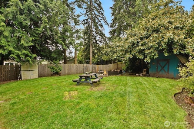 view of yard with a fenced backyard, an outdoor structure, and a shed
