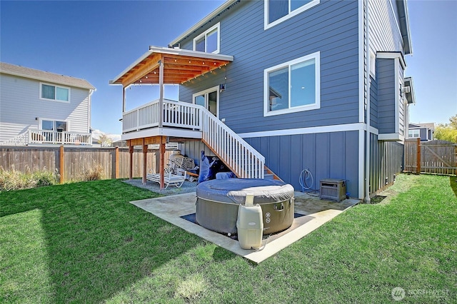 back of house with a patio, a wooden deck, a fenced backyard, a lawn, and board and batten siding