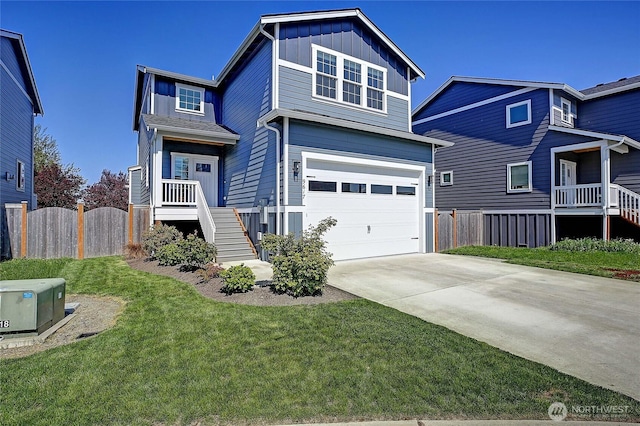 view of front of property with board and batten siding, concrete driveway, a front yard, fence, and a garage