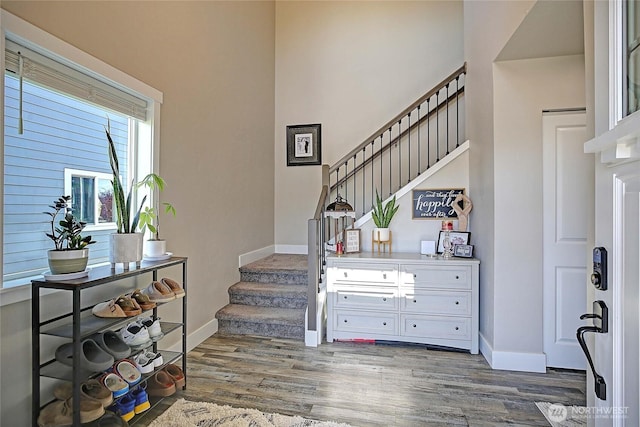 entrance foyer featuring stairway, wood finished floors, and baseboards