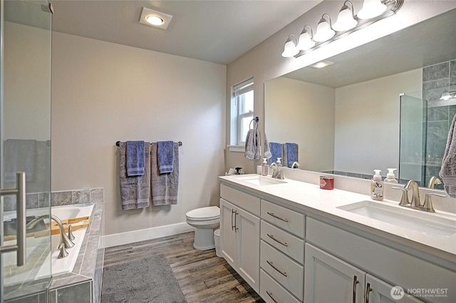 full bathroom with wood finished floors, toilet, baseboards, and a sink