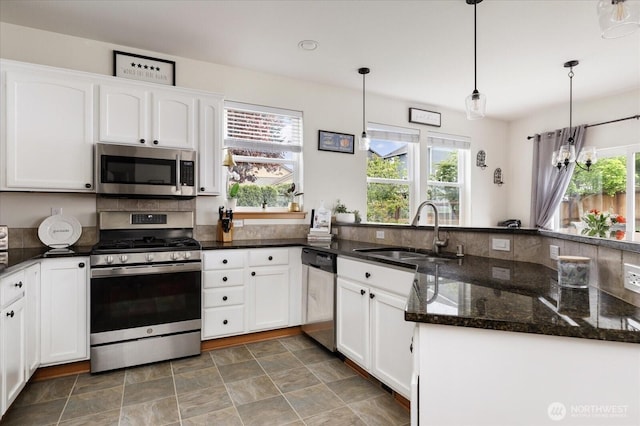 kitchen featuring white cabinets, stainless steel appliances, plenty of natural light, and a sink