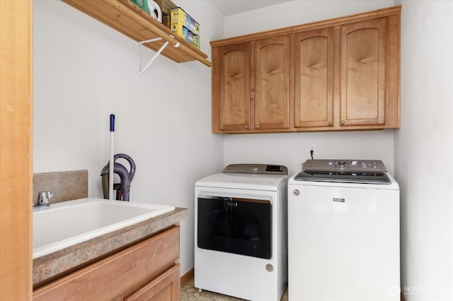 clothes washing area featuring a sink, cabinet space, and washer and dryer