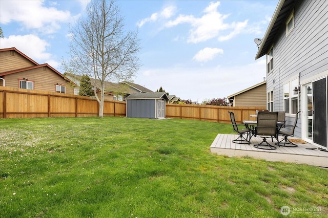 view of yard with a storage unit, a fenced backyard, and an outbuilding