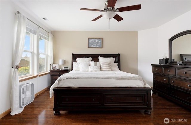 bedroom featuring baseboards, a ceiling fan, and dark wood-type flooring
