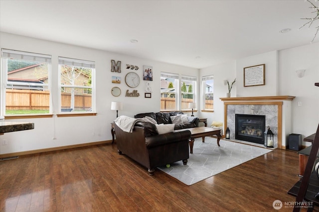 living area with a healthy amount of sunlight, hardwood / wood-style floors, and a tile fireplace