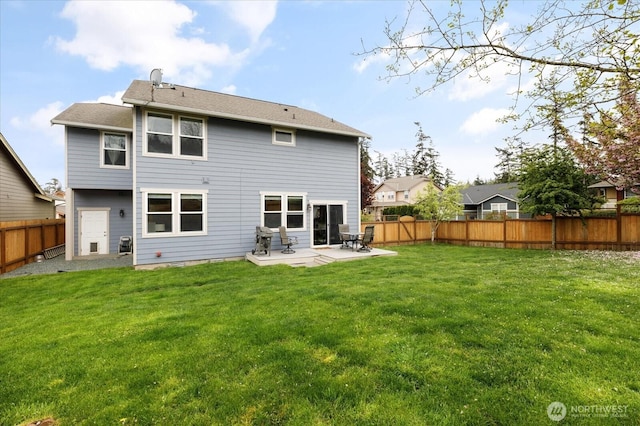 rear view of property featuring a yard, a fenced backyard, and a patio area