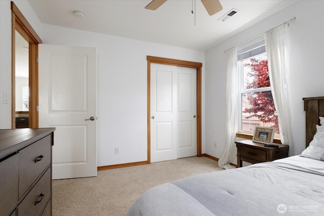 bedroom featuring baseboards, visible vents, light carpet, and ceiling fan