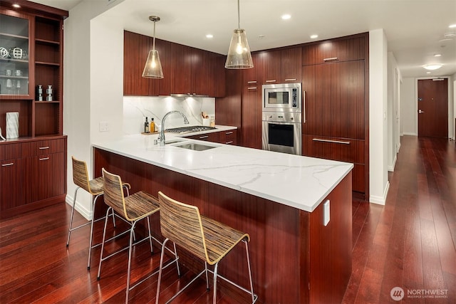 500 106th Ave NE Unit 611, Bellevue, WA 98004 - kitchen featuring appliances with stainless steel finishes, a sink, modern cabinets, dark wood-type flooring, and a peninsula